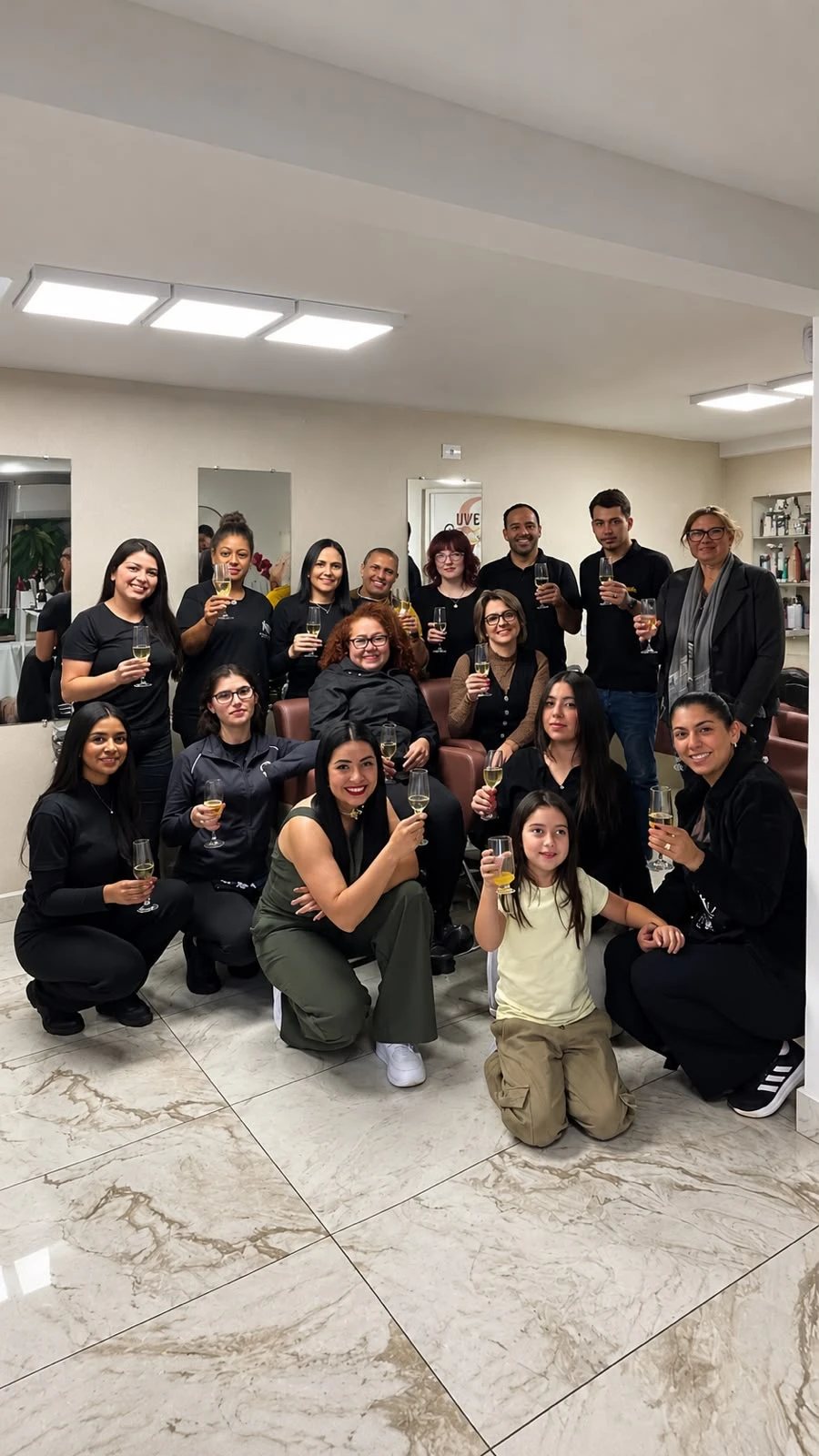 Equipe do Salão Kharina Ribeiro reunida no salão, brindando juntas